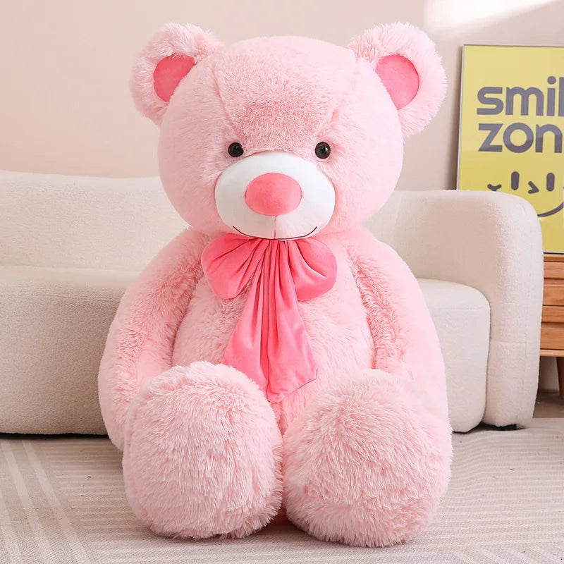 Urso de pelúcia grande rosa com laço rosa no pescoço 